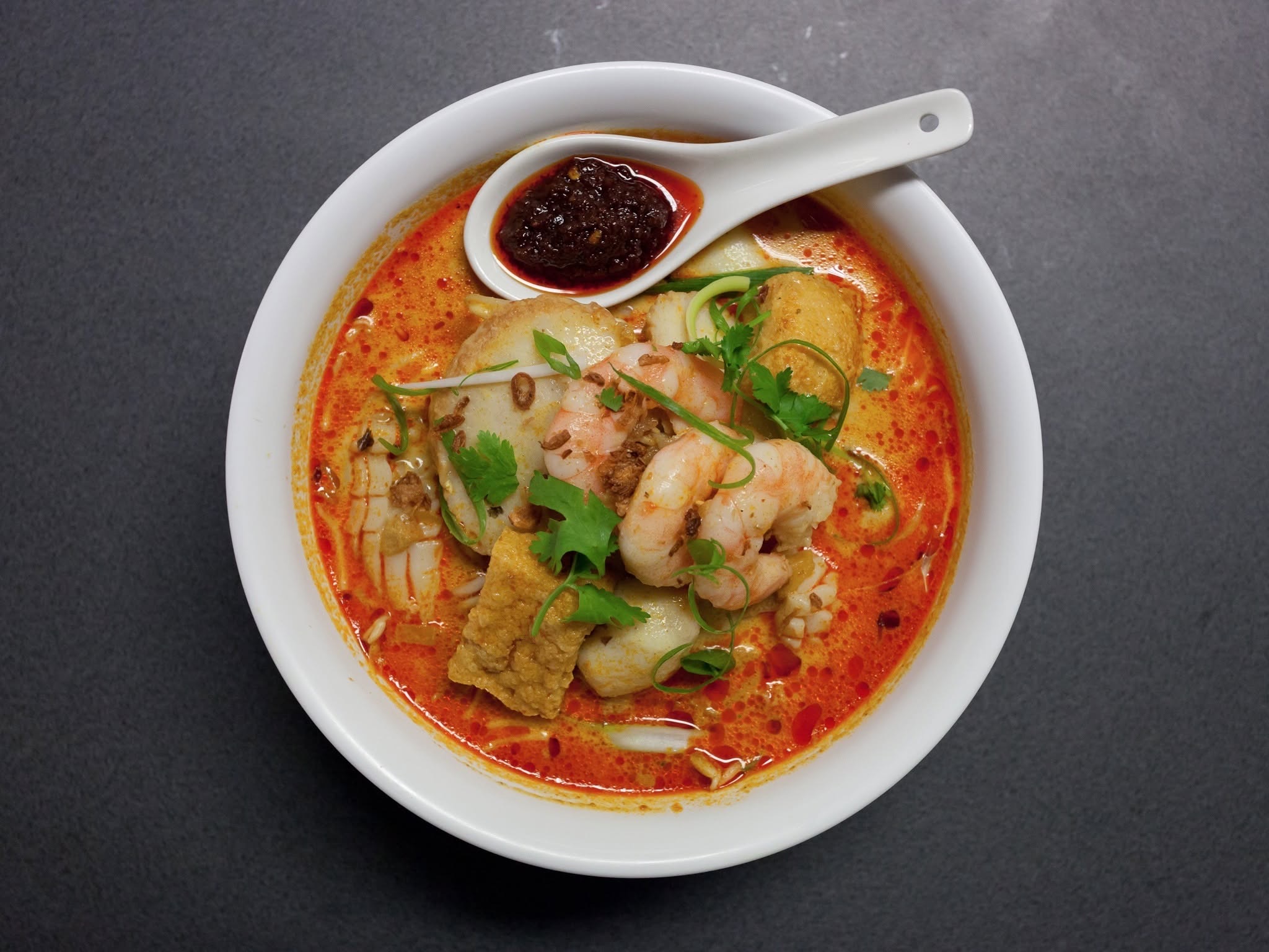 Bowl of laksa with noodles, prawns and a rich spiced broth